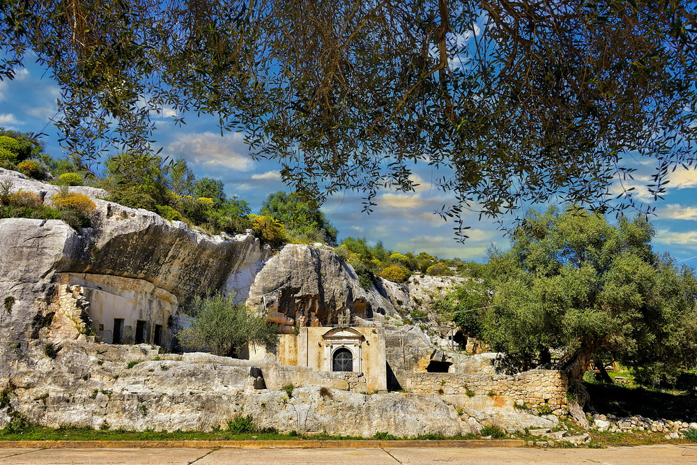Insediamenti rupestri e vegetazione su costa rocciosa